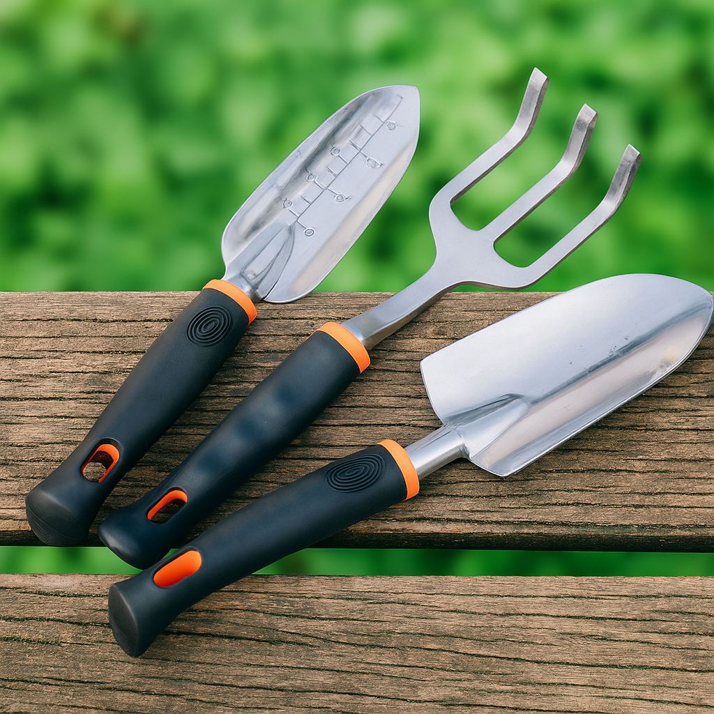 Three garden tools laid on a wooden surface with soft green background