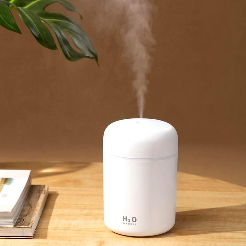 White Color Cup USB Air Humidifier emitting mist on a wooden surface with a plant in the background