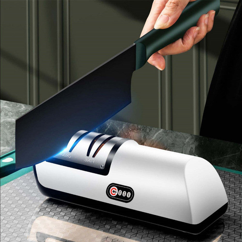 Demonstration of electric knife sharpener in action, sharpening a cleaver on a kitchen countertop.