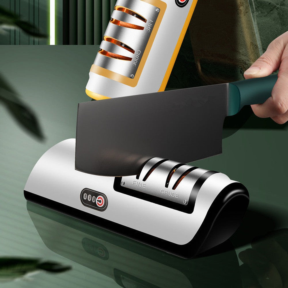 Electric knife sharpener being used to sharpen a cleaver, with dual-slot design labeled “FINE” and “CRUDE”.