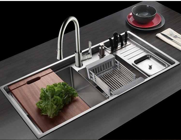 Expandable stainless steel sink basket placed in a modern kitchen sink setup, perfect for washing and draining vegetables.