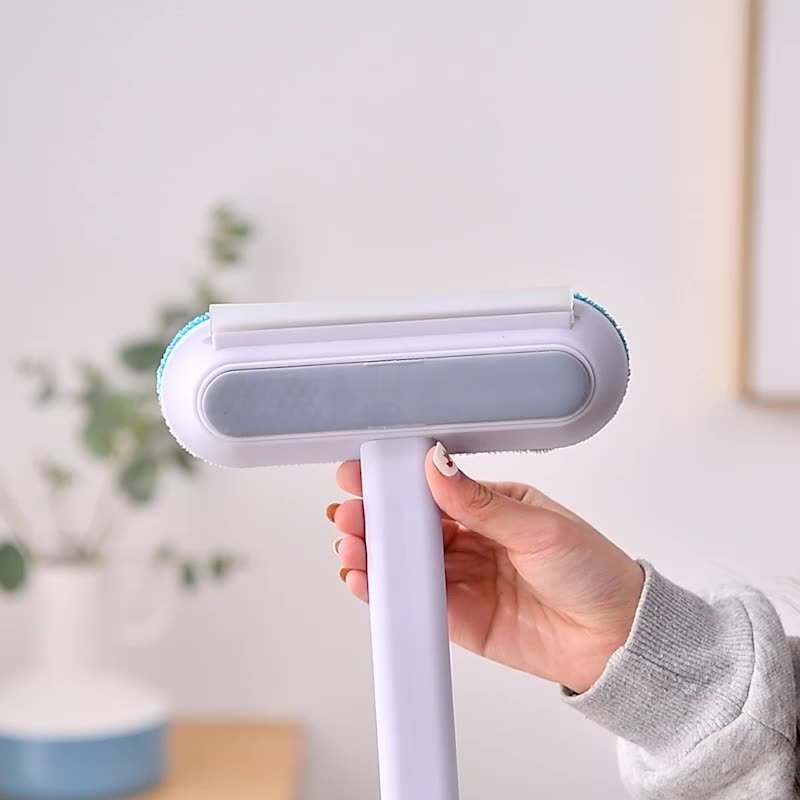 Close-up of handheld pet hair removal brush in modern home setting