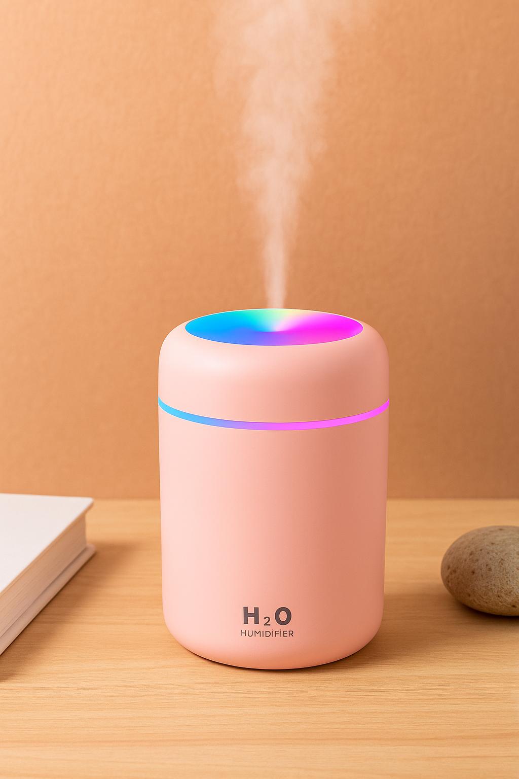 Pink Color Cup USB Air Humidifier with LED light on a wooden surface, soft peach background, book and stone decor