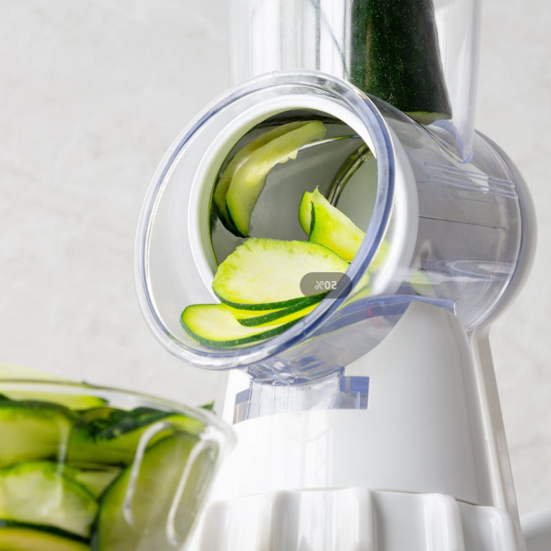 Close-up of manual vegetable cutter slicing zucchini with rotary blade into a glass bowl.