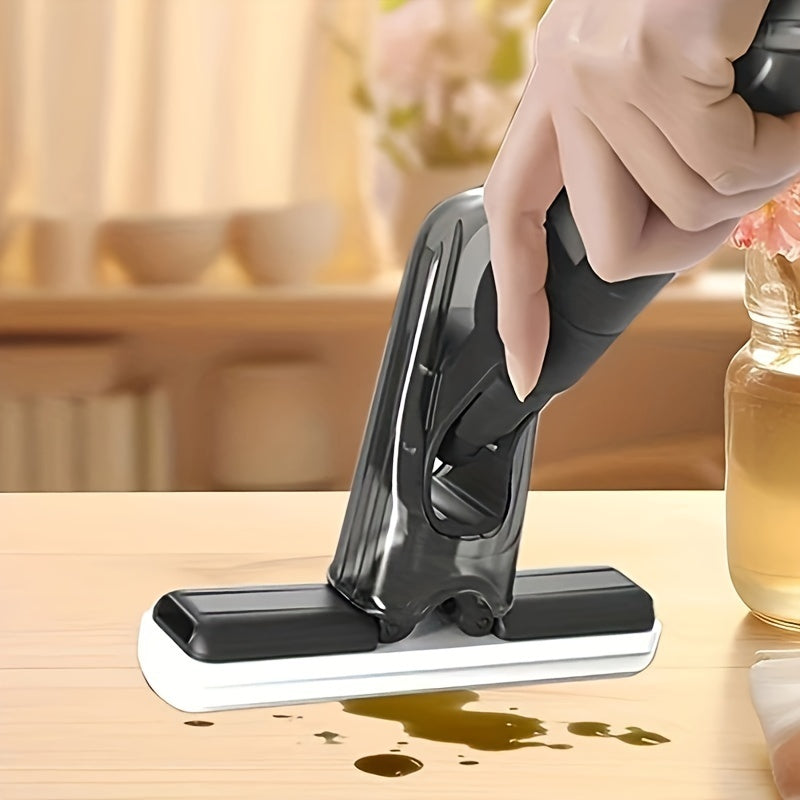 Mini spray mop cleaning spilled liquid from a wooden table surface