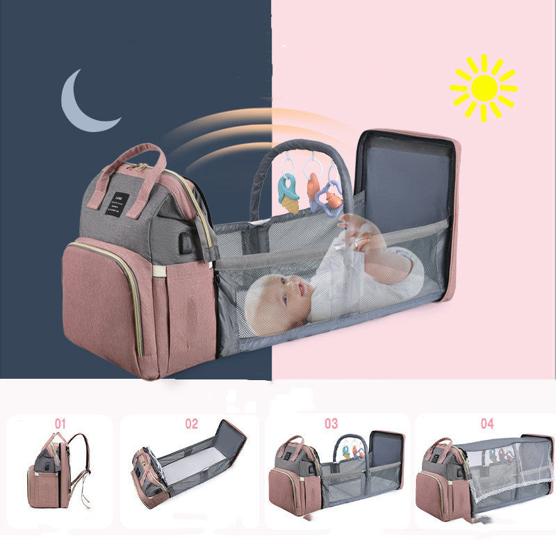 Multifunctional mummy backpack with foldable crib and baby inside, perfect for travel and diaper changes.