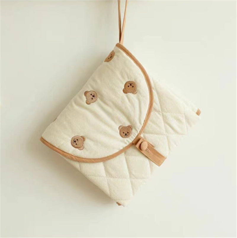 Portable baby changing pad with cute bear pattern, folded for travel, variant view