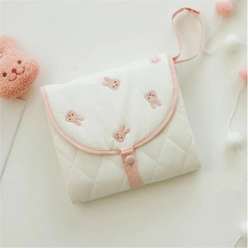 Portable baby changing pad with cute rabbit pattern, folded for travel