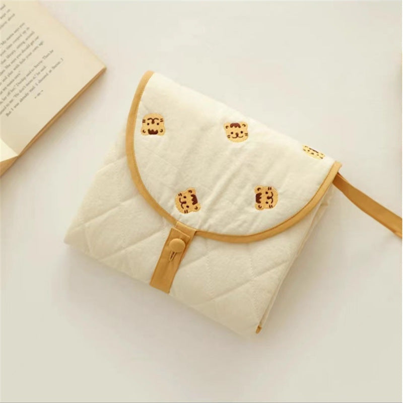 Portable baby changing pad with cute tiger pattern, folded for travel