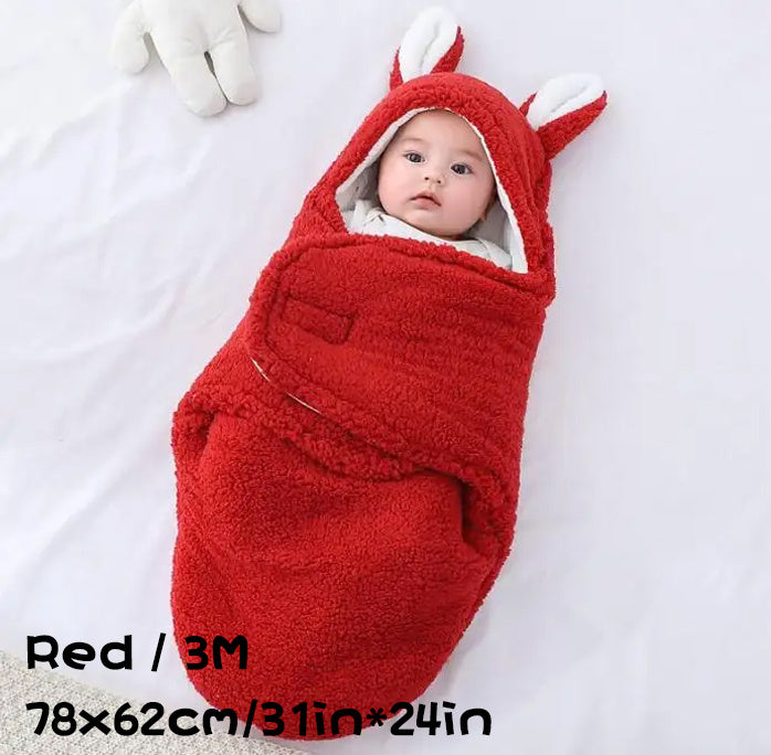 Baby in a red fluffy swaddle sleeping bag with bunny ears, labeled "Red / 3M, 78×62cm / 31in×24in".
