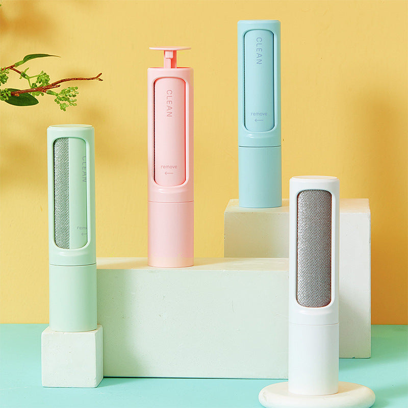 Reusable pet hair remover brush in white, blue, pink, and green colors displayed on blocks