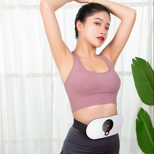 Woman wearing a slimming and heating belt on her waist while stretching