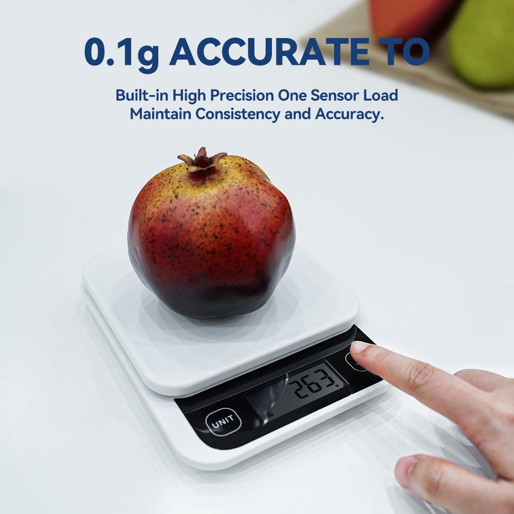 Close-up of a digital smart kitchen scale with a pomegranate on top and a finger pressing the tare button, showing a reading of 263 grams.