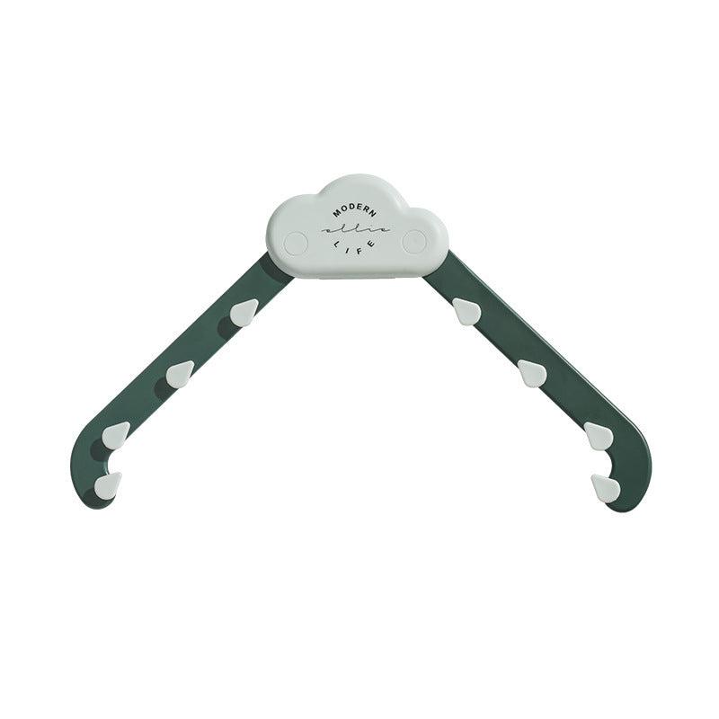Triangular sink filter holder with green arms and cloud-shaped top, shown on white background