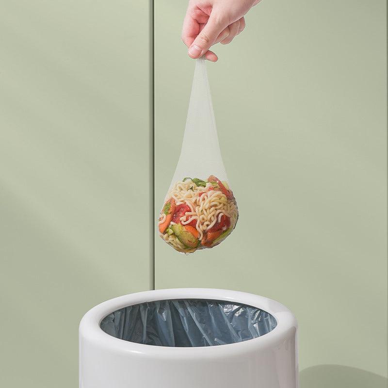 Disposable mesh filter bag filled with food waste being held above a trash bin for easy disposal
