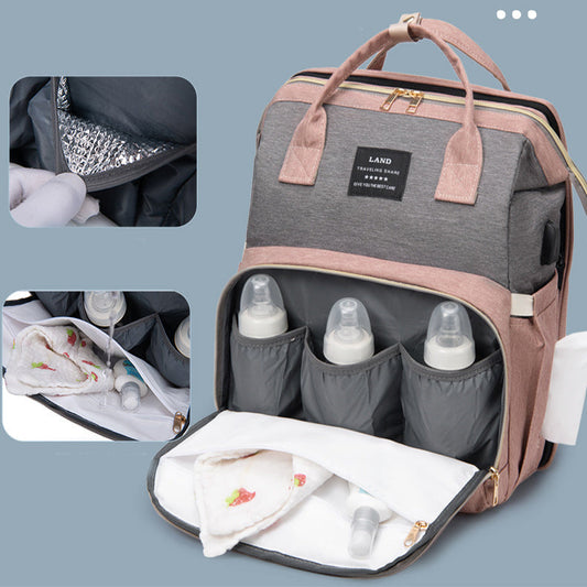 Front view of diaper backpack with open insulated pocket holding three baby bottles, featuring waterproof lining and organized interior compartments.