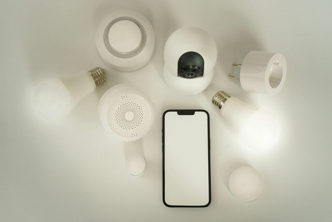 Smart home gadgets and smartphone on white background representing affordable innovation with mini technology.