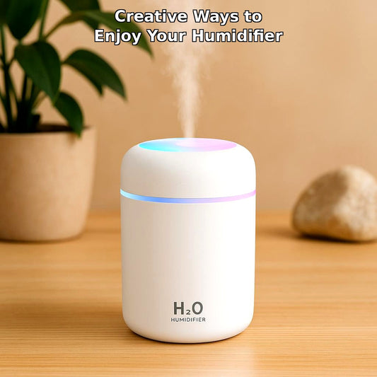 White USB colorful cup air humidifier on wooden table with green plant in background, text overlay "Creative Ways to Enjoy Your Humidifier"
