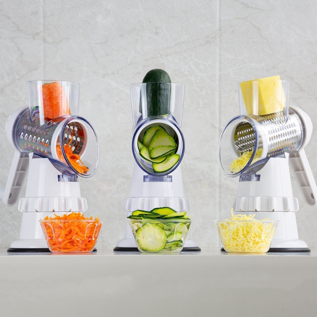 Manual 3-in-1 vegetable cutter being used to slice and grate various vegetables into bowls.