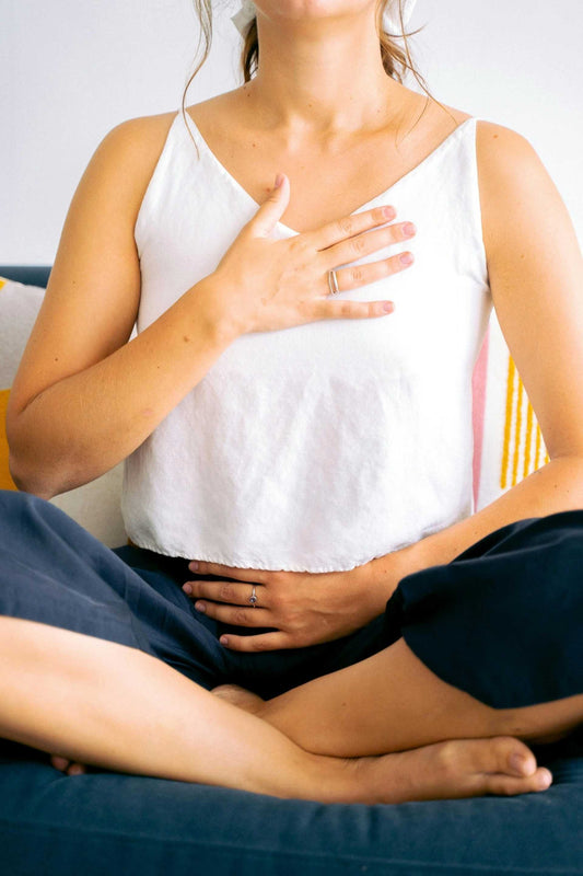 Woman practicing micro-meditation with hands on chest and abdomen