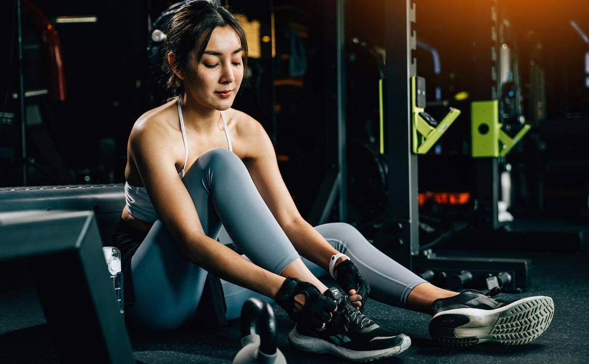 Young woman in athletic wear preparing for a workout at the gym, representing HiveCart’s commitment to health, wellness, and active living.