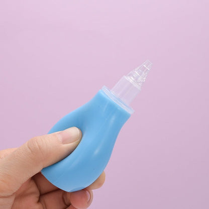 Blue baby nasal aspirator with transparent tip held in hand against a pink background