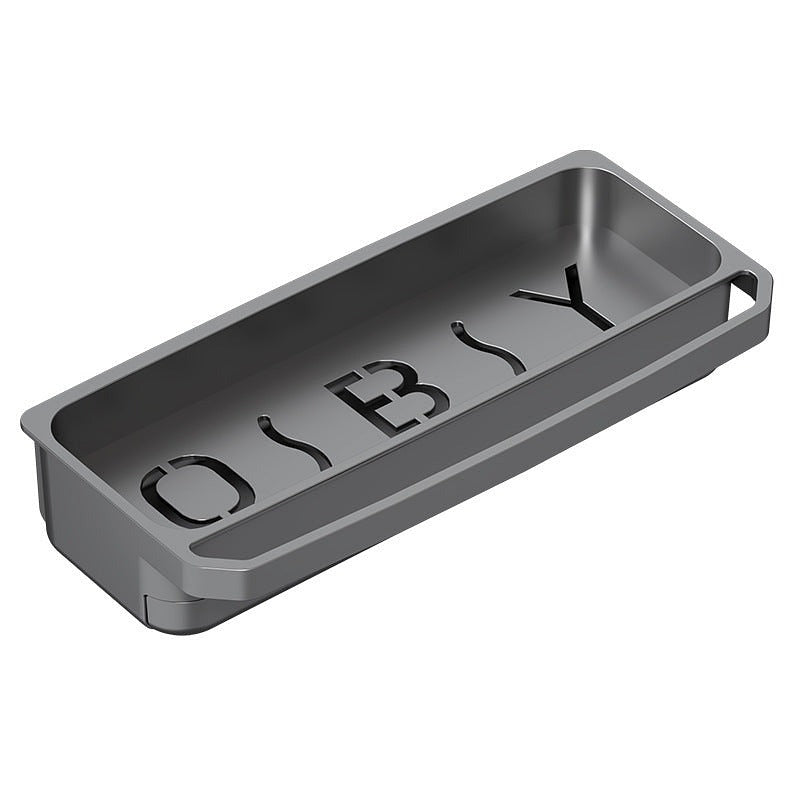 Close-up of an empty dark gray kitchen sink organizer tray with cut-out lettering in the base