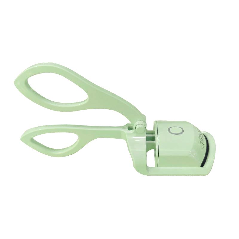 Green heated eyelash curler with ergonomic handle on white background