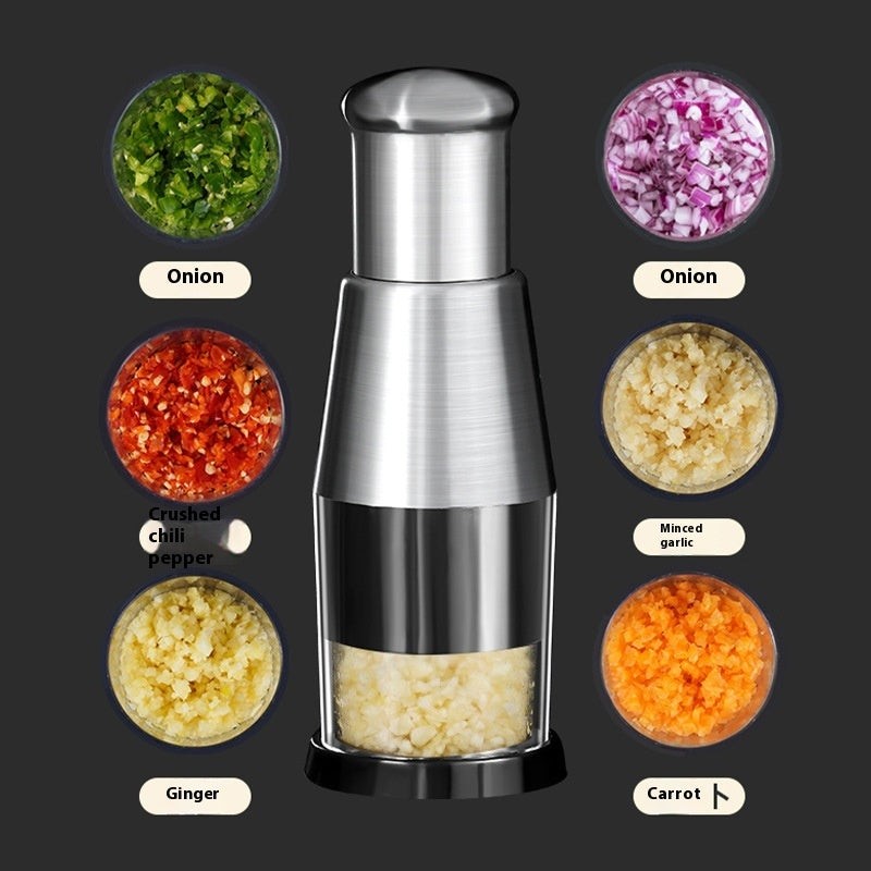 Manual garlic and onion press surrounded by chopped vegetables including onion, garlic, carrot, ginger, and chili pepper.