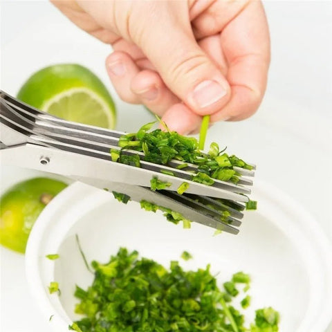 Close-up of multi-layer herb scissors cutting fresh chives over a bowl