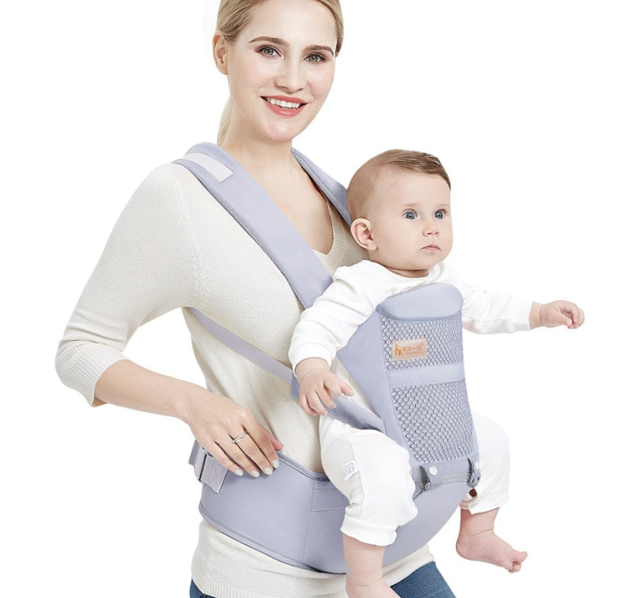 Smiling mother carrying baby in ergonomic grey baby carrier with waist stool – front view