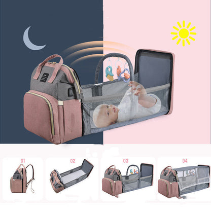 Multifunctional mummy backpack with foldable crib and baby inside, perfect for travel and diaper changes.