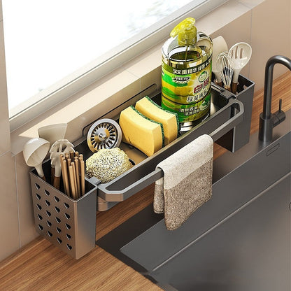 Over-sink kitchen organizer holding dish soap, sponges, utensils, and towels in a modern kitchen setting