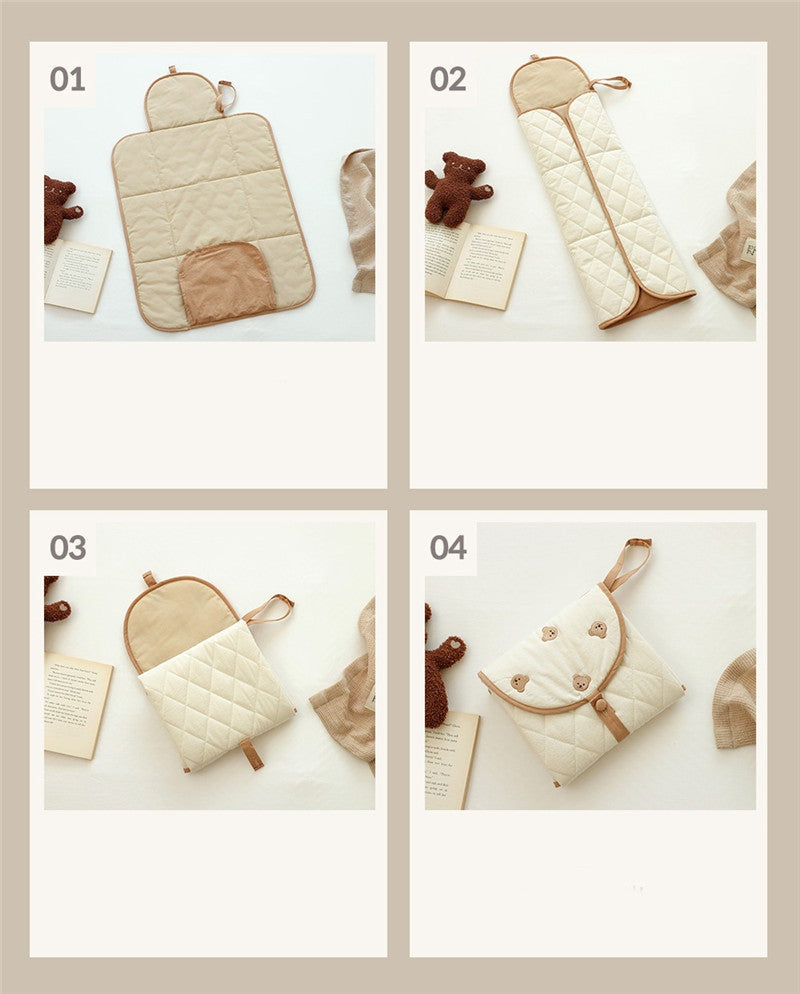 Portable baby changing pad with bear pattern, shown in four views: open, folded lengthwise, partially folded, and fully folded