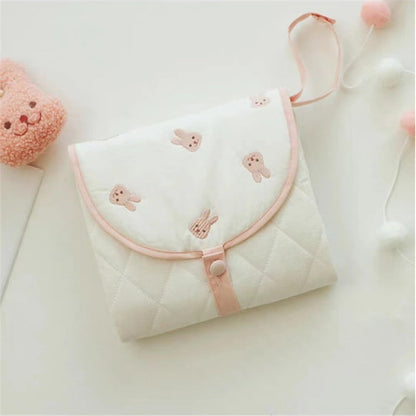 Portable baby changing pad with cute rabbit pattern, folded for travel