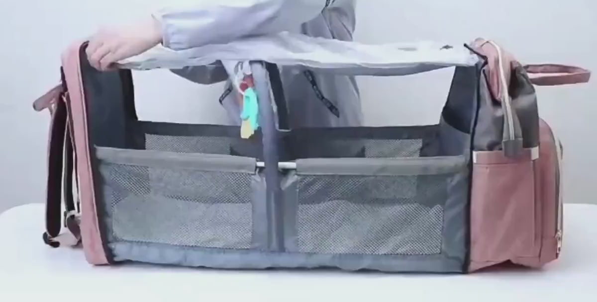 Product video of the Mummy Baby Crib Backpack showing how it unfolds into a portable crib and highlights the insulated bottle holders