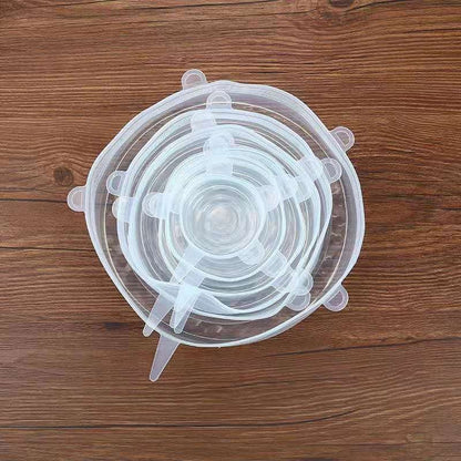 Top view of stacked silicone food lids in multiple sizes on wooden surface