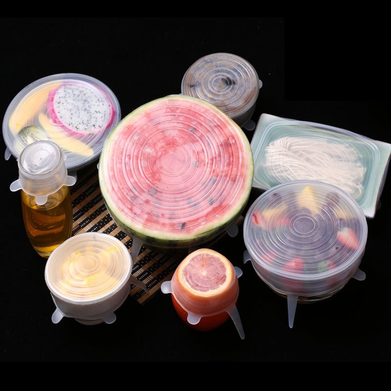 Assorted containers and fruits sealed with silicone lids on black background