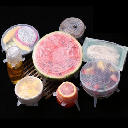Assorted containers and fruits sealed with silicone lids on black background