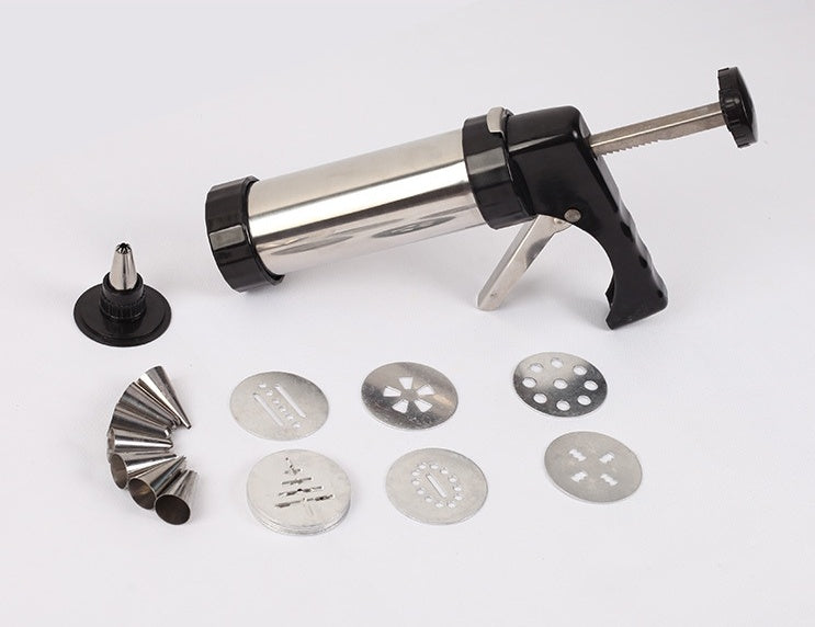Disassembled stainless steel cookie press with icing tips and cookie discs on white background