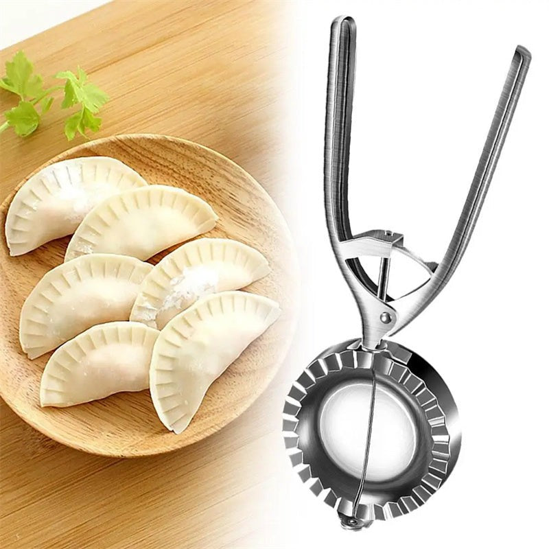 Stainless steel dumpling maker next to plate of freshly made dumplings on wooden table