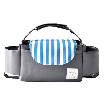 Gray stroller organizer bag with a blue and white striped flap, photographed on a white background, showing side compartments and a central pocket.