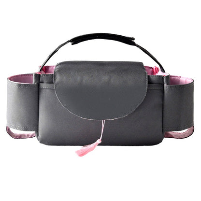 Gray stroller organizer bag with pink interior and a pink tassel on the flap, photographed on a white background.