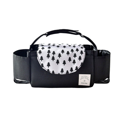 Black stroller organizer bag with a white flap featuring a tree pattern, photographed on a white background, showing cup holders and a central compartment.